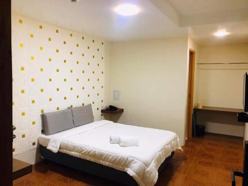 a bedroom with a bed and a wall with yellow dots at I'm Inn Hotel Sorsogon near SM or Terminal in Sorsogon