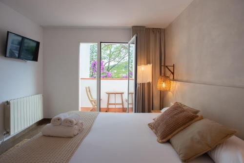 een slaapkamer met een bed met twee handdoeken erop bij Hostal Es Niu de Tamariu in Tamariu