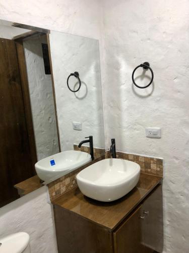 a bathroom with a white sink and a mirror at TOSCANA de Tomine in Guatavita