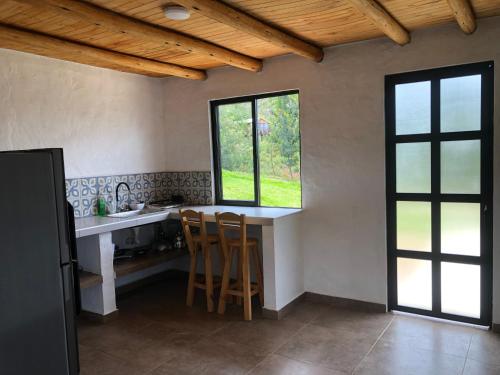 a kitchen with a counter and a sink and two windows at TOSCANA de Tomine in Guatavita