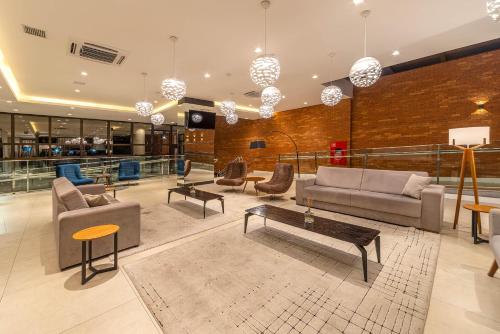 um átrio com sofás e mesas num edifício em Hotel Laghetto Estação em Bento Gonçalves