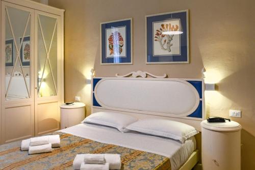 Hotel La Pace في فياريجيو: غرفة نوم عليها سرير وفوط