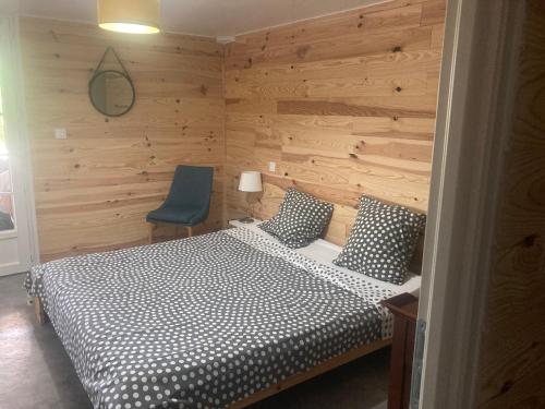 une chambre avec un lit et une chaise bleue dans l'établissement GITE Sitio Nathalie et Jos, à Saint-Laurent-de-Carnols