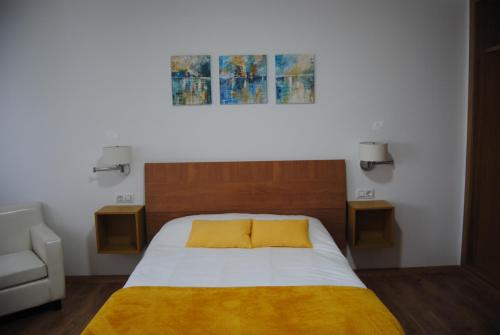 Un dormitorio con una cama con una manta amarilla. en Anduriña 2, en Monforte de Lemos