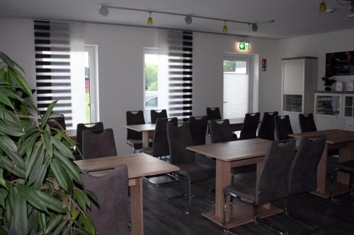 a conference room with tables and chairs and a plant at Hotel HeideZeiten in Walsrode