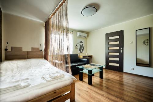 um quarto com uma cama, uma cadeira e uma mesa em Apartament Szczecinek - Spokojna okolica em Szczecinek