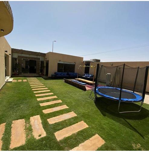 einen Hof mit einem Trampolin und einem Gebäude in der Unterkunft Arabs Chalet in Buraida