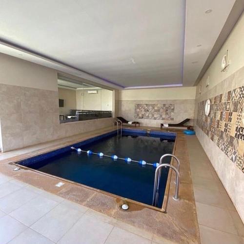 een groot zwembad in een grote kamer met bij Arabs Chalet in Buraydah