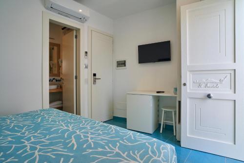 a bedroom with a bed and a desk and a television at il Truciolo Suite in Anacapri
