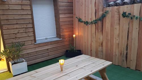 une table en bois devant un mur en bois dans l'établissement Chez Mélissa, à Millau