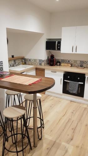 - une cuisine avec une table et des tabourets dans l'établissement Chez Mélissa, à Millau