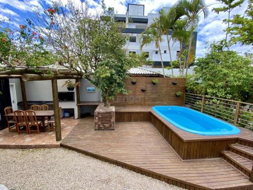 a backyard with a hot tub and a table and chairs at 273 - Lindo apto 01 dormitório na Praia de Mariscal in Bombinhas