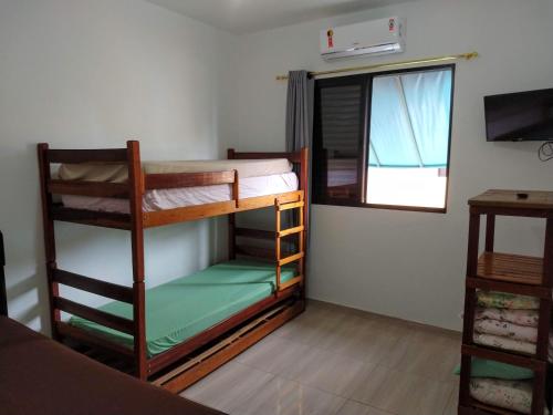 カラグアタトゥーバにあるRecanto Jubarte (Massaguaçu Caraguatatuba - SP)の二段ベッド2台と窓が備わる客室です。