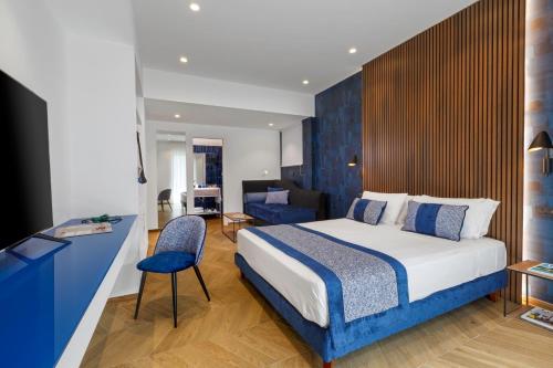 Dreamers' Rooms Sorrento في سورينتو: غرفة نوم مع سرير ومكتب مع كرسي
