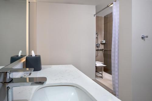 a white bathroom with a sink and a shower at Hyatt House Lewes Rehoboth Beach in Lewes