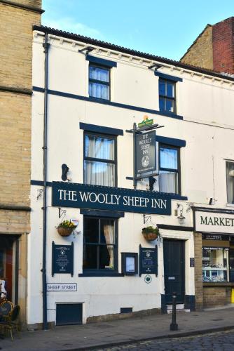 a white building with a sign that reads the woolly sheep inn at The Woolly Sheep Inn in Skipton