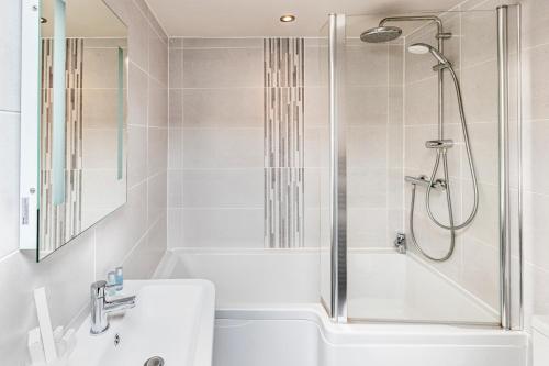 a white bathroom with a shower and a tub and a sink at The Woolly Sheep Inn in Skipton