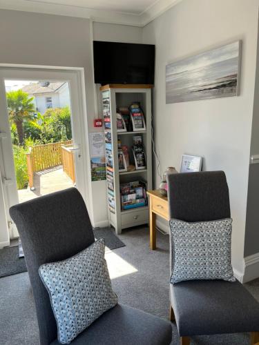 two chairs in a room with a desk and a door at Bentley Lodge in Torquay