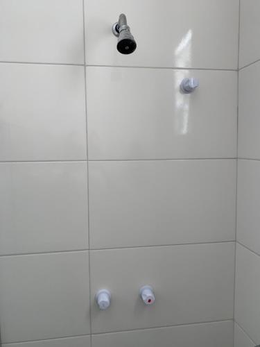 a white shower with a shower head and lights at Casa da Gina in Santa Cruz Cabrália
