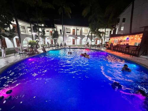 a group of people swimming in a pool at night at Hotel El Bosque in Jaén