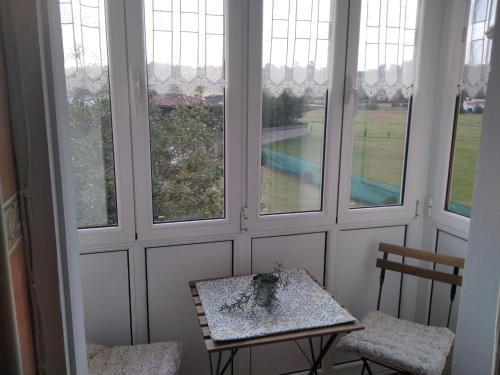 a room with a table and two chairs and windows at Casa Bayona in Santiago del Monte