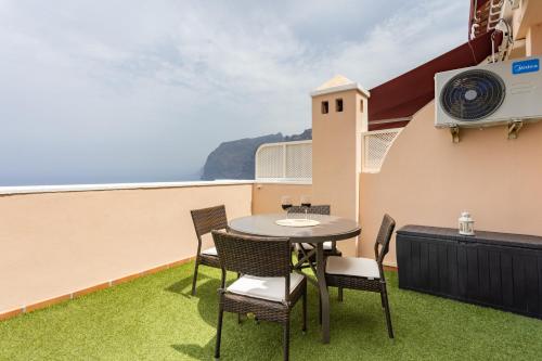 een patio met een tafel en stoelen op een balkon bij Unique Buenavista in Santiago del Teide