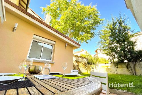 un tavolo in legno con bicchieri da vino su un patio di CLIM Jolie maison de 60 m2 avec jardin a Limoges