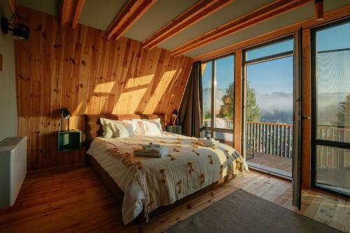a bedroom with a bed and a large window at Krest relaxing heights in Vatra Dornei