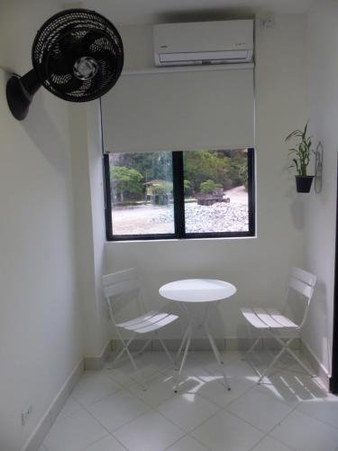 a table and chairs in a room with a window at Campo Godoy in Doradal
