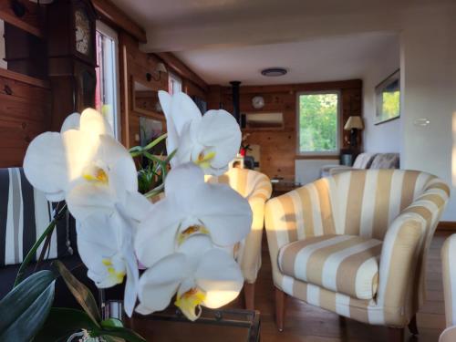 a living room with white flowers on a table at Le reposoir in Mont-Saxonnex