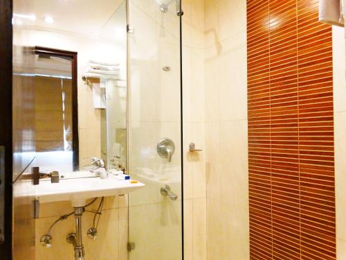 a bathroom with a sink and a shower at The Legend Inn Delhi in New Delhi