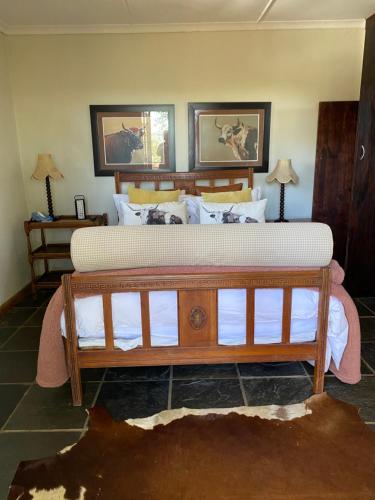 Un dormitorio con una gran cama de madera con sábanas blancas. en Cabbage Tree Cottage en Hilton