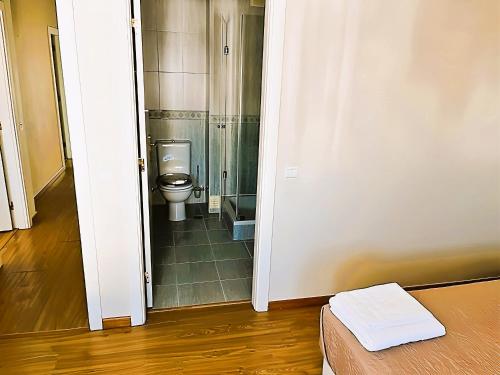 ein Badezimmer mit einem WC und einer Glastür in der Unterkunft Flat 3 Bedrooms Albufeira in Albufeira