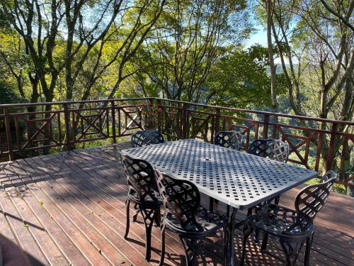 a table and chairs on a wooden deck at Cabbage Tree Cottage in Hilton