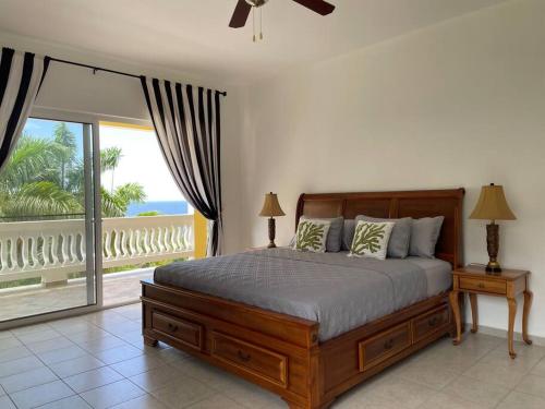 1 dormitorio con 1 cama grande y balcón en Spring Garden Mobay Resort Luxurious Apartments en Montego Bay