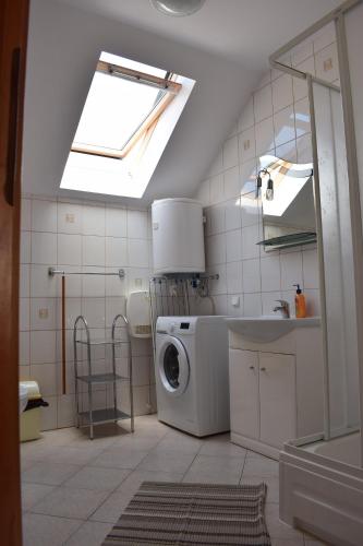 a kitchen with a washing machine and a skylight at Dom Muszelka in Lubiatowo
