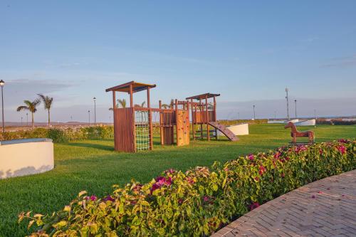 a park with a playground with a horse in the grass at Karibao Resort Town in Playas