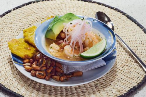 a plate of food with a bowl of soup and beans at Karibao Resort Town in Playas