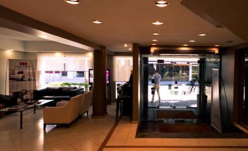 a man standing in a lobby looking out the door at Hotel Hernandarias in Santa Fe