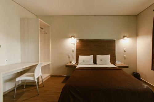 - une chambre avec un lit, un bureau et une chaise dans l'établissement Hotel Guivá Aeropuerto, à Oaxaca