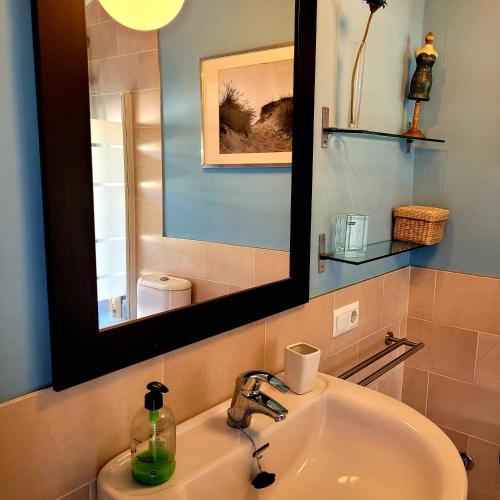 a bathroom with a sink and a mirror at Mi casa playera in El Rompido