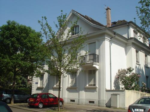 a red car parked in front of a white building at Studio des Musiciens - quartier Orangerie in Strasbourg