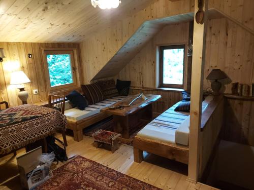 ein Zimmer mit einem Sofa und einem Bett in einer Hütte in der Unterkunft ŠUMSKA KUĆA 1 in Rakovica
