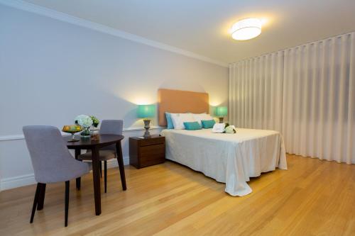 um quarto com uma cama, uma secretária e uma mesa em Casa dos Troviscais em Lousã