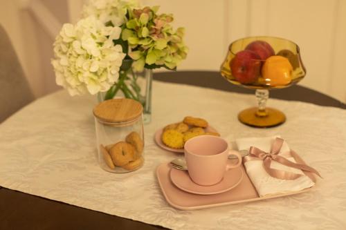 una mesa con una taza de café y un plato de fruta en Casa dos Troviscais, en Lousã