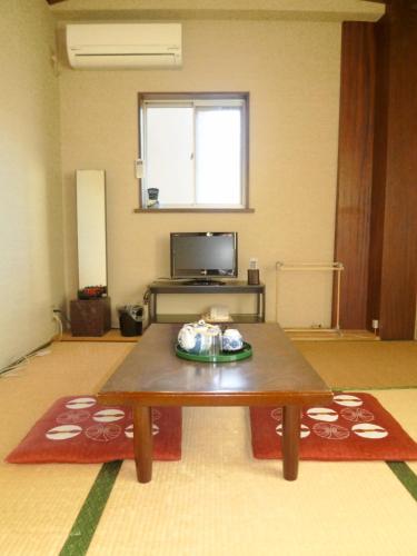 un soggiorno con tavolino e TV di Imazato Ryokan - Vacation STAY 03276v ad Osaka