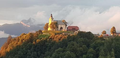 a house on a hill with a church on it at Le reposoir in Mont-Saxonnex