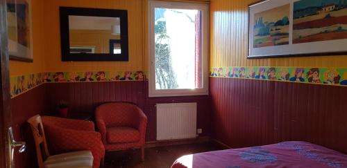 a bedroom with a bed and a window and a chair at Le reposoir in Mont-Saxonnex