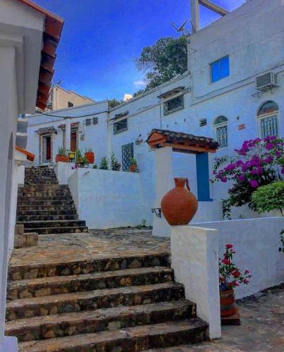 a white house with stairs and a vase on a wall at Campo Godoy in Doradal