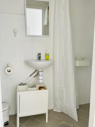 a white bathroom with a sink and a toilet at Endla Hostel ja Apartamendid in Haapsalu